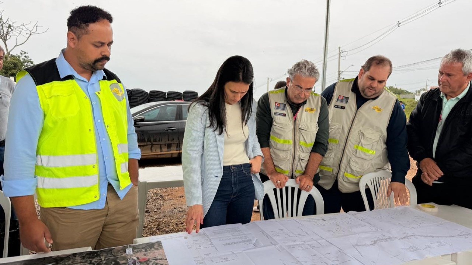 Natália Resende analisa plantas da pavimentação com equipe do DER durante visita técnica